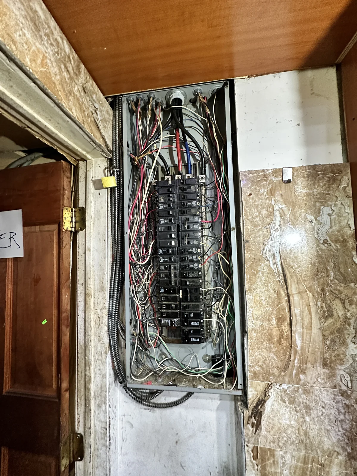Older electrical panels and wiring opened for licensed electrician review