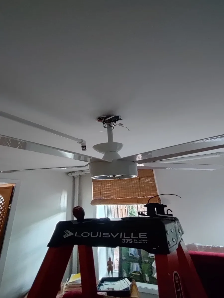 Ceiling-fan installation in progress Electrician mounting a ceiling fan during a New York City residential installation
