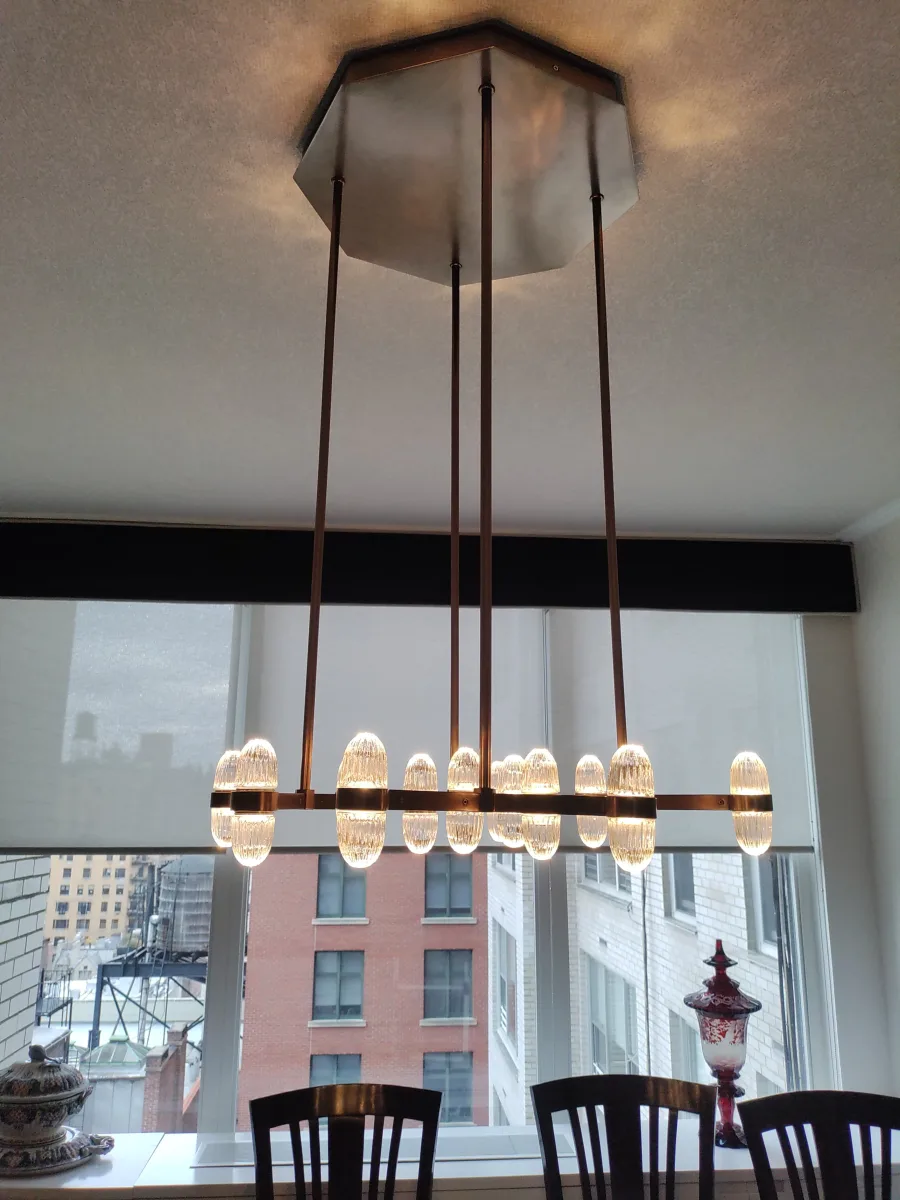 Modern chandelier installed above a New York City dining room table