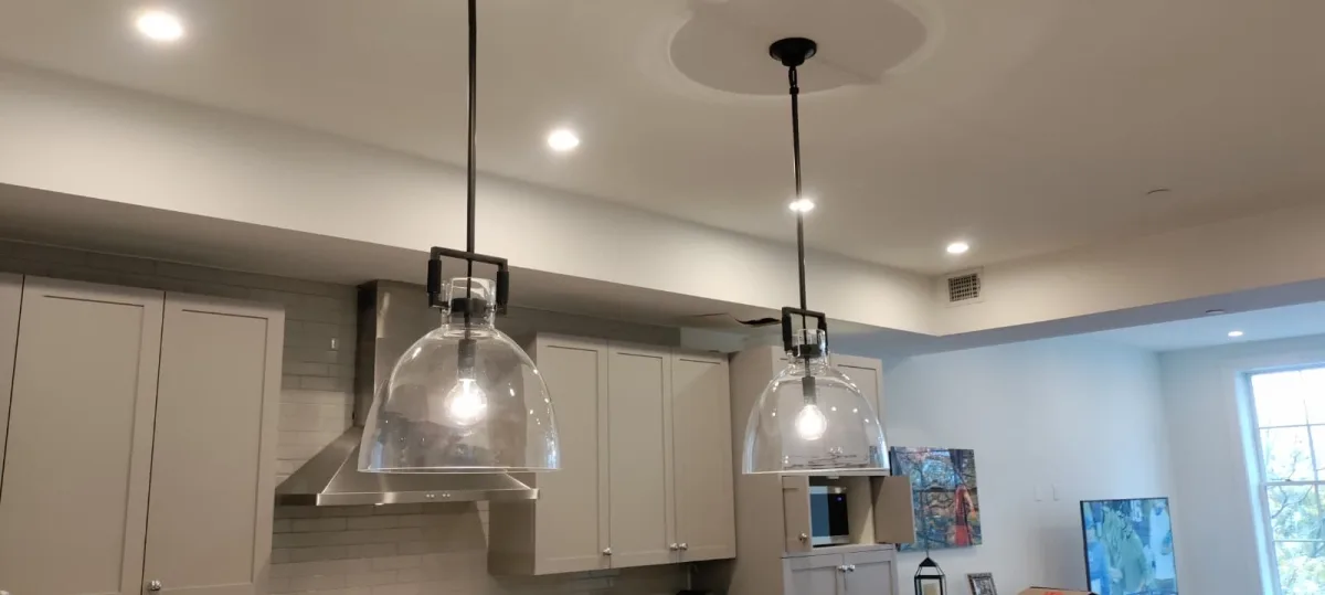 Two glass pendant lights installed above a New York City kitchen island