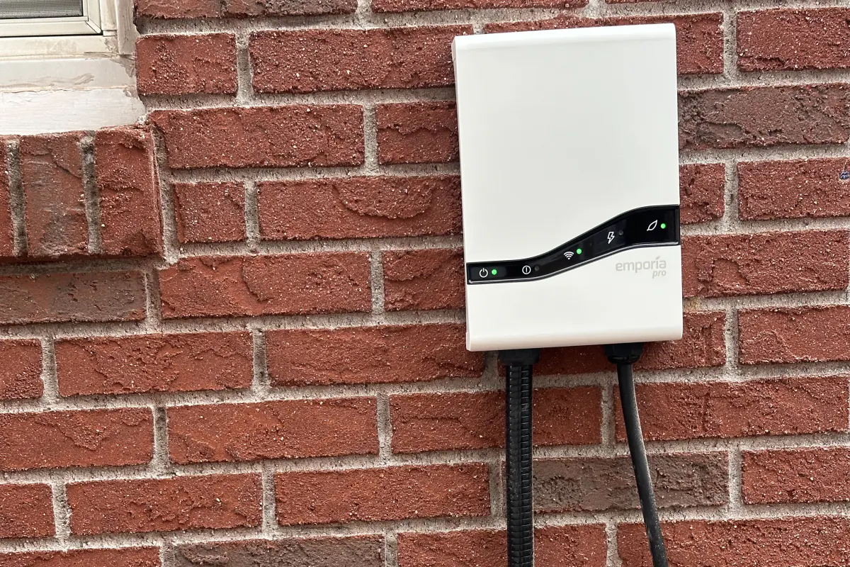 Wall-mounted Emporia Level 2 EV charger installed on a brick exterior at a New York City home