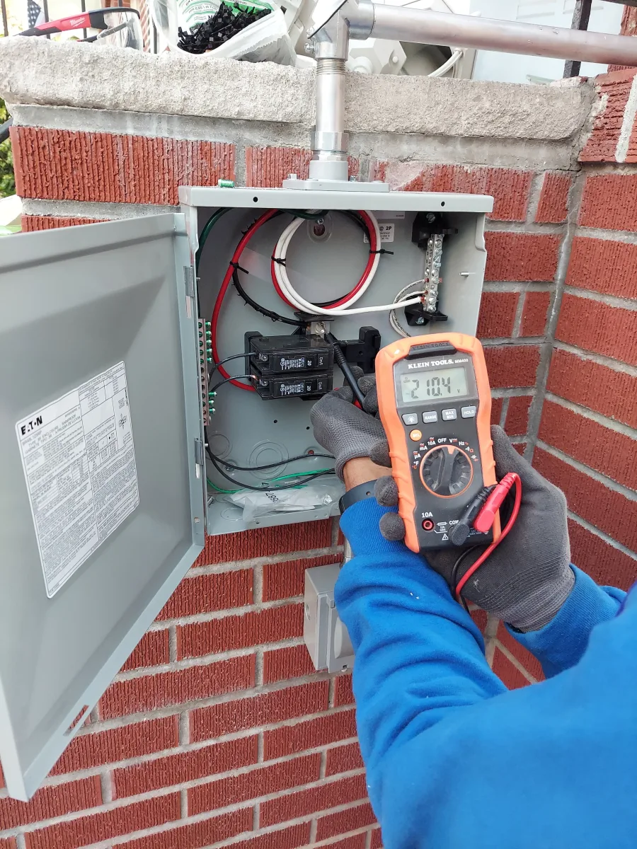 Electrical Panel Voltage Testing in NYC Electrician testing voltage at an electrical panel with a digital multimeter during New York City electrical troubleshooting